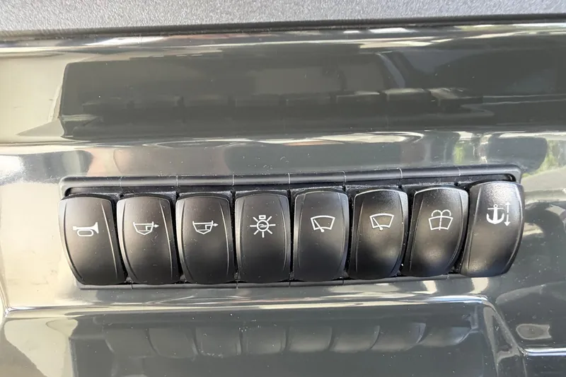 Slide: The Image of Control panel switches on a 2025 Bayliner Trophy T23 Pilothouse boat dashboard. - 25