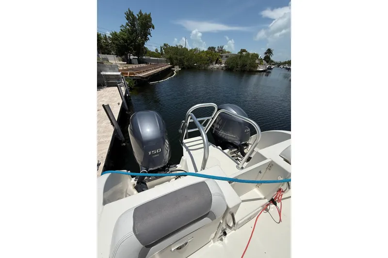 Slide: The Image of 2018 World Cat 255 DC boat with dual 150 horsepower engines docked by a serene waterway. - 5