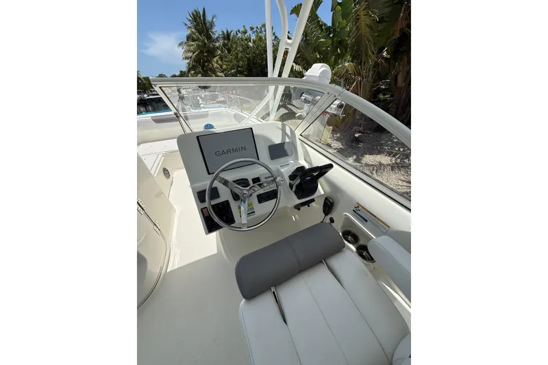 Slide: The Image of 2018 World Cat 255 DC boat cockpit with Garmin navigation system, surrounded by tropical foliage. - 8