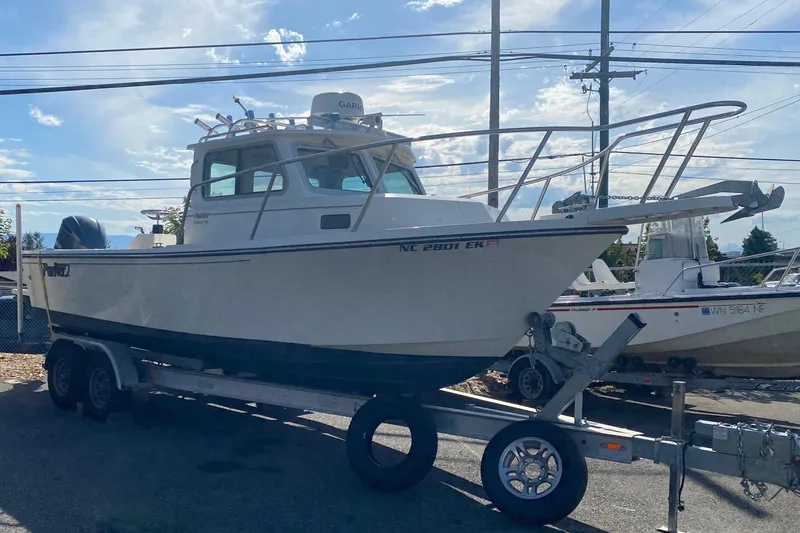 The Image of 2019 Parker 2320 SL Sport Cabin boat on trailer under clear sky. - 0