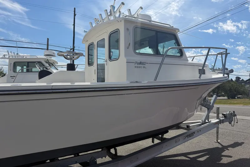 Slide: The Image of 2019 Parker 2320 SL Sport Cabin boat on trailer under clear sky. - 1