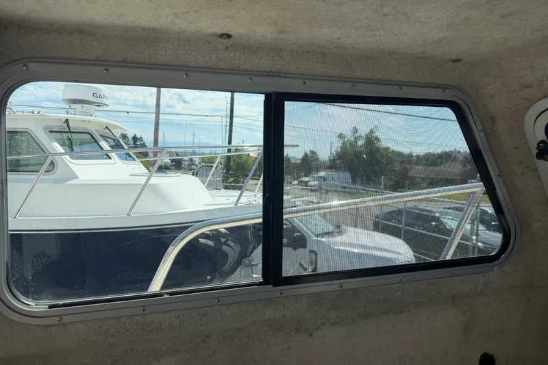 Slide: The Image of Interior view from a 2019 Parker 2320 SL Sport Cabin, showing a boat through the window. - 21