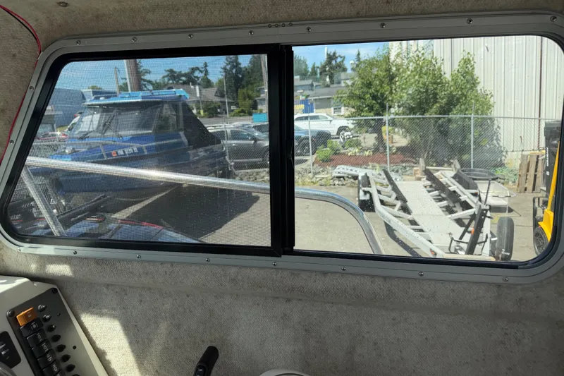 Slide: The Image of Interior view from a 2019 Parker 2320 SL Sport Cabin, showing a boatyard outside. - 22