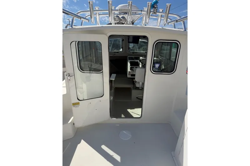 Slide: The Image of 2019 Parker 2320 SL Sport Cabin boat interior with open door and visible cockpit. - 30
