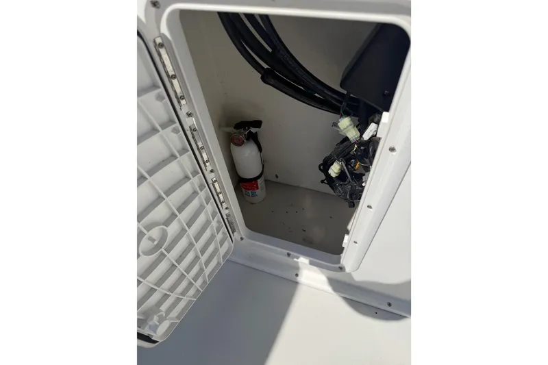 Slide: The Image of Open storage compartment in 2019 Parker 2320 SL Sport Cabin with fire extinguisher and wiring. - 33