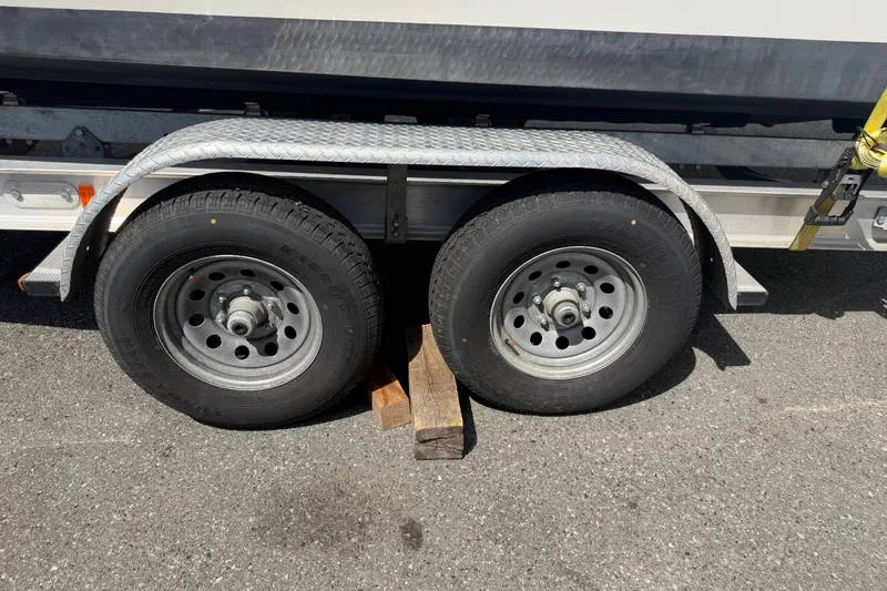 Slide: The Image of Trailer wheels of a 2019 Parker 2320 SL Sport Cabin, secured with wooden blocks. - 45