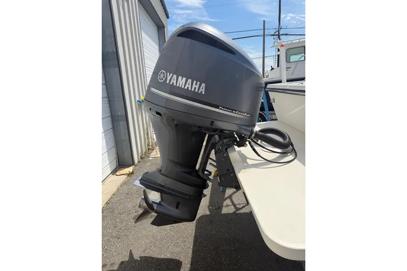 Slide: The Image of Yamaha outboard motor on a 2019 Parker 2320 SL Sport Cabin boat, parked outdoors. - 51