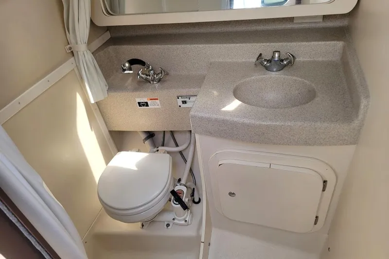 Slide: The Image of Compact bathroom in a 2006 Catalina 310 sailboat with sink, toilet, and storage. - 11