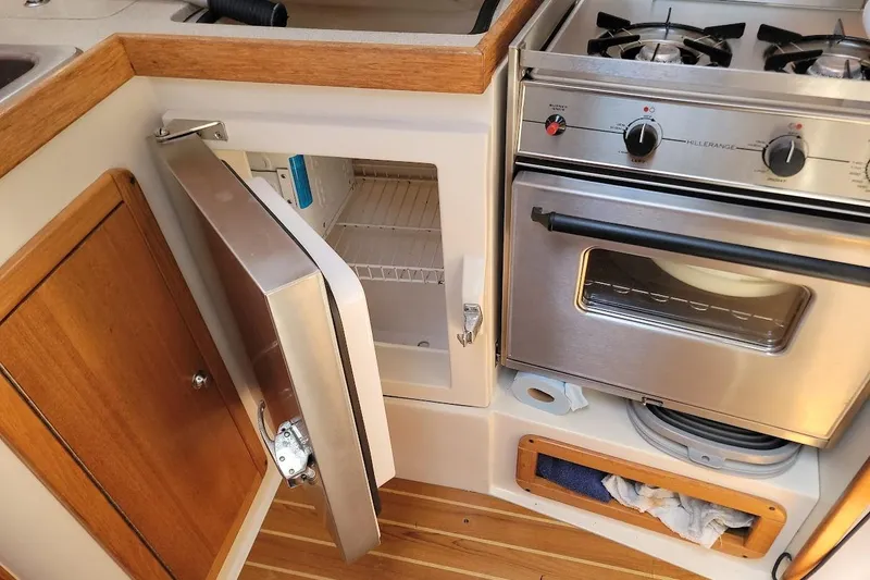 Slide: The Image of Catalina 310 yacht kitchen with open fridge and stove, 2006 model. - 16