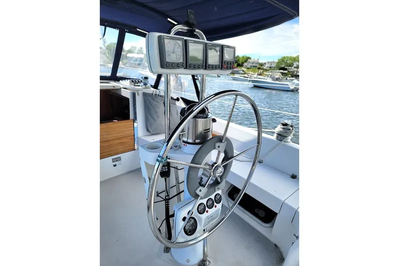 Slide: The Image of Steering wheel and controls of a 2006 Catalina 310 sailboat, docked in a marina. - 17