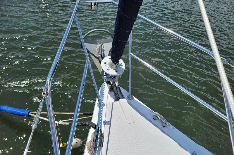 Slide: The Image of Bow of 2006 Catalina 310 sailboat with stainless steel railing on water. - 20