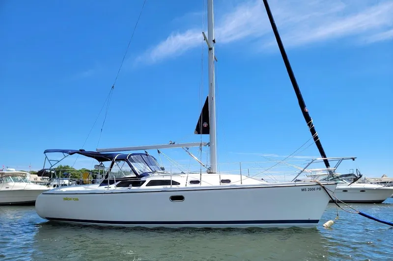 Slide: The Image of 2006 Catalina 310 sailboat anchored in a sunny marina with clear blue skies. - 25