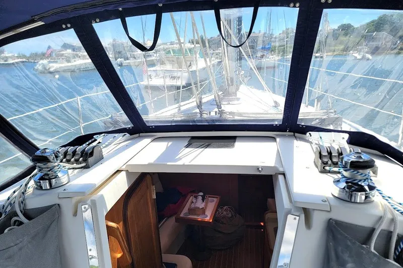 Slide: The Image of Cockpit view of a 2006 Catalina 310 sailboat, showcasing winches and marina backdrop. - 3