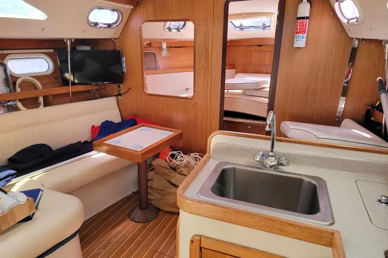 Slide: The Image of Interior of a 2006 Catalina 310 sailboat with cozy seating and kitchenette. - 4