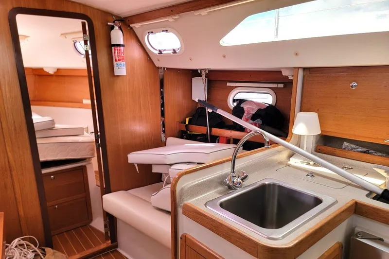 Slide: The Image of Interior of a 2006 Catalina 310 sailboat featuring a compact kitchen and cozy cabin space. - 7