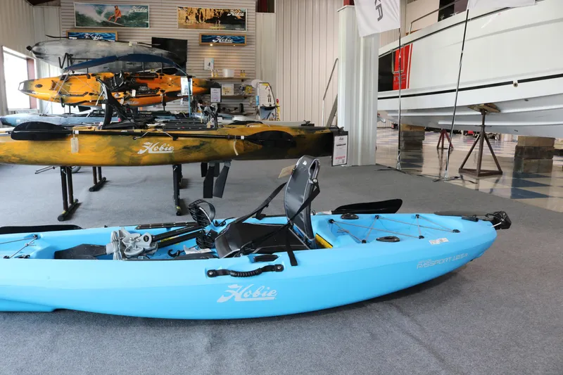 Slide: The Image of 2024 Hobie Mirage Passport 10.5 R kayak displayed in a showroom setting. - 7