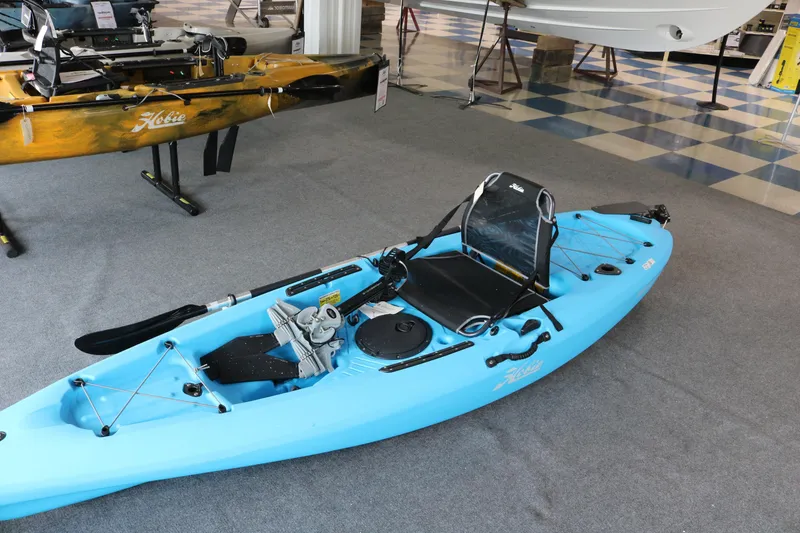 Slide: The Image of 2024 Hobie Mirage Passport 10.5 R kayak in showroom, featuring pedal drive system. - 8