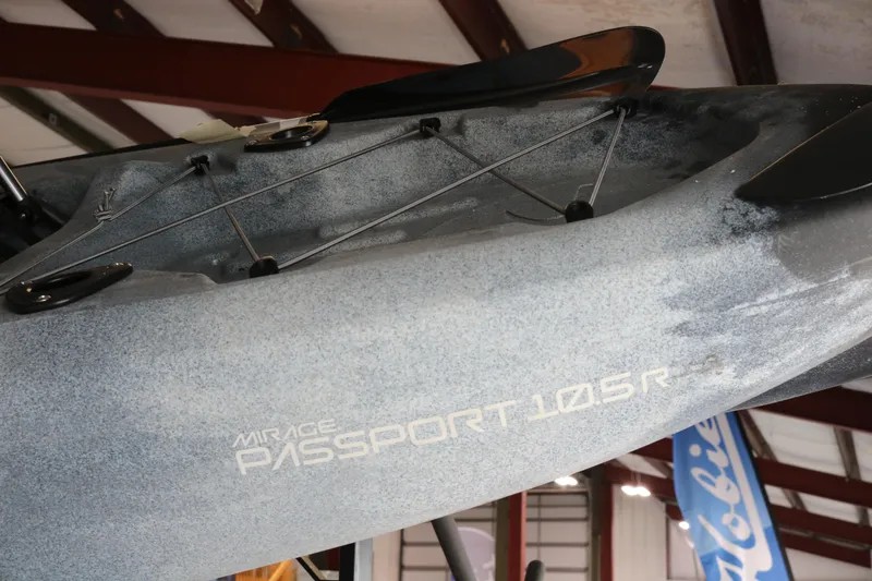 Slide: The Image of 2024 Hobie Mirage Passport 10.5 R kayak displayed indoors, showcasing sleek design and branding. - 2