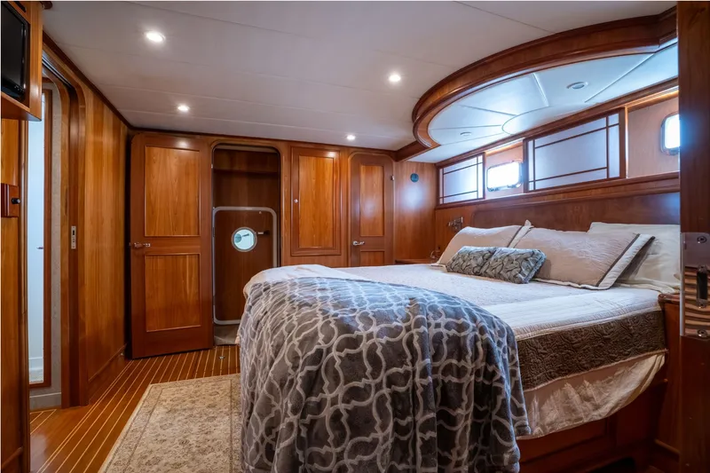 Slide: The Image of Luxurious 2009 Outer Reef Yachts motor yacht bedroom with elegant wood paneling and cozy bedding. - 18