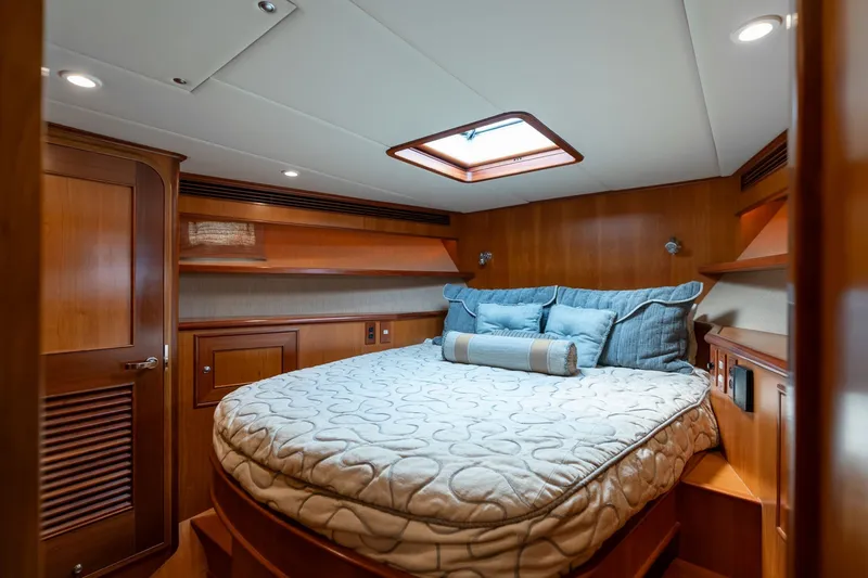 Slide: The Image of Luxurious 2009 Outer Reef Yachts motor yacht bedroom with elegant wood paneling and cozy bedding. - 25
