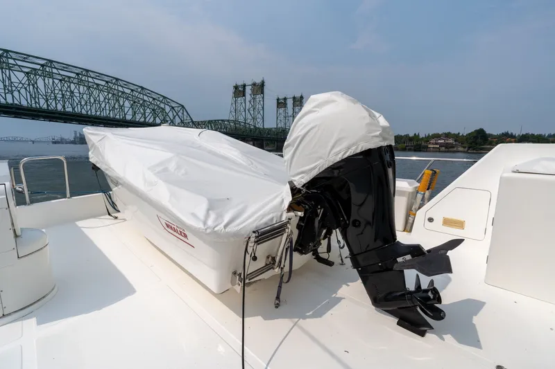 Slide: The Image of 2009 Outer Reef Yachts Motor Yacht with covered outboard motor near a bridge. - 33