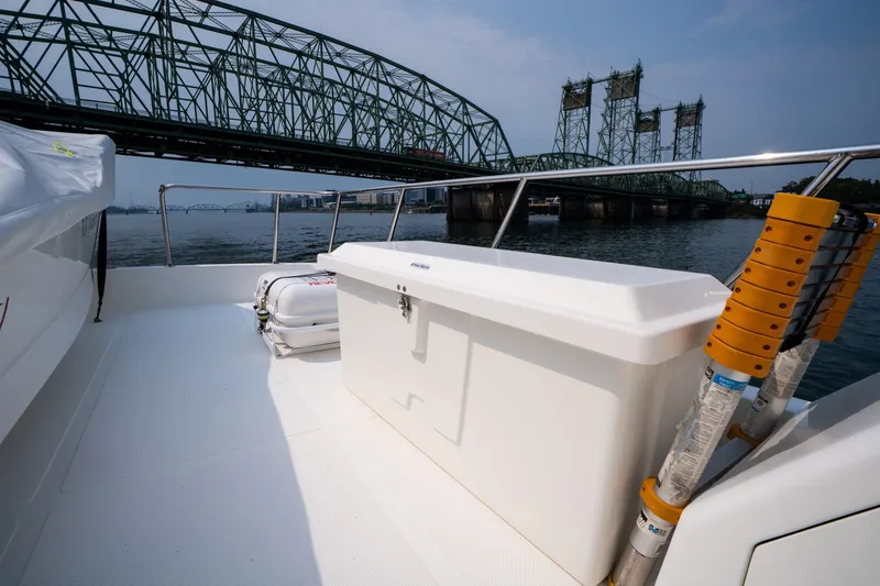 Slide: The Image of 2009 Outer Reef Yachts Motor Yacht deck with storage box, near a bridge over water. - 32