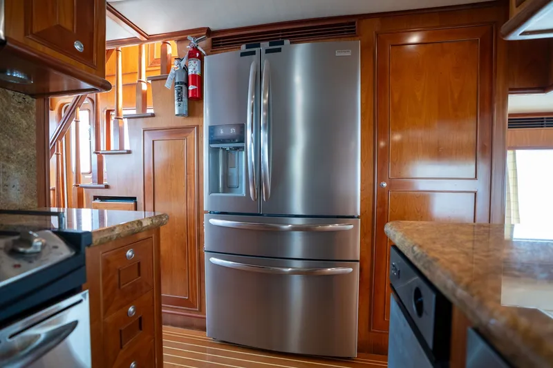 Slide: The Image of Luxurious 2009 Outer Reef Yachts motor yacht kitchen with stainless steel refrigerator and wooden cabinetry. - 10