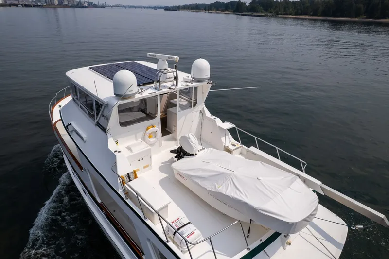 Slide: The Image of 2009 Outer Reef Yachts Motor Yacht cruising on calm waters, featuring solar panels and covered equipment. - 57