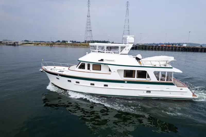 The Image of 2009 Outer Reef Yachts Motor Yacht cruising on calm waters near a shoreline. - 2