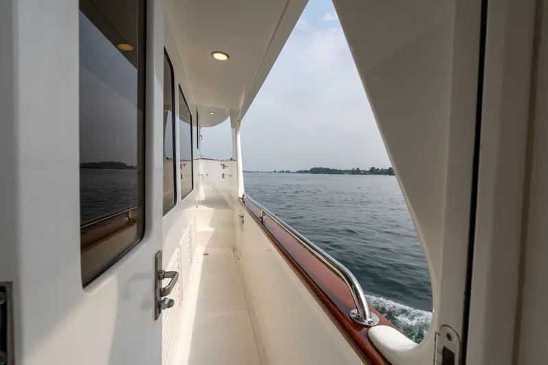 Slide: The Image of Side deck view of a 2009 Outer Reef Yachts Motor Yacht cruising on calm waters. - 36