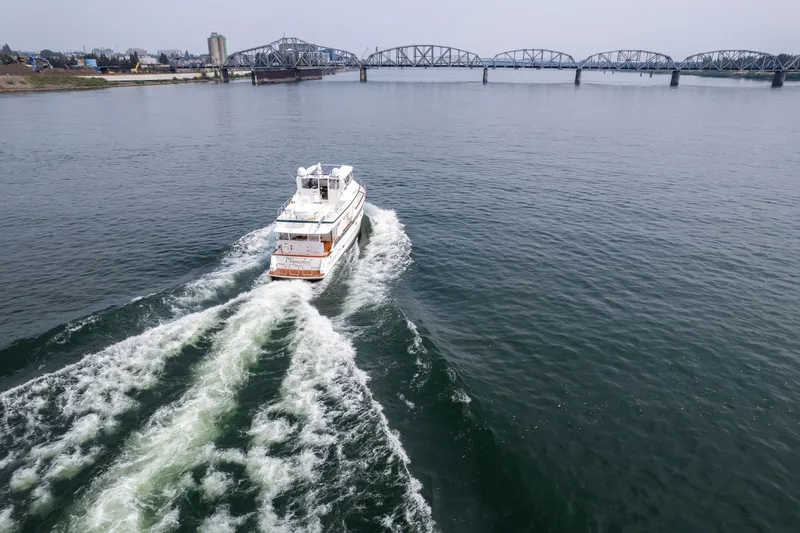 Slide: The Image of A 2009 Outer Reef Yachts motor yacht cruising near a bridge on a calm river. - 70