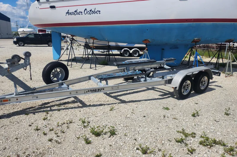 Slide: The Image of Boat trailer beside a yacht named "Another October" in a marina, sunny day. - 11