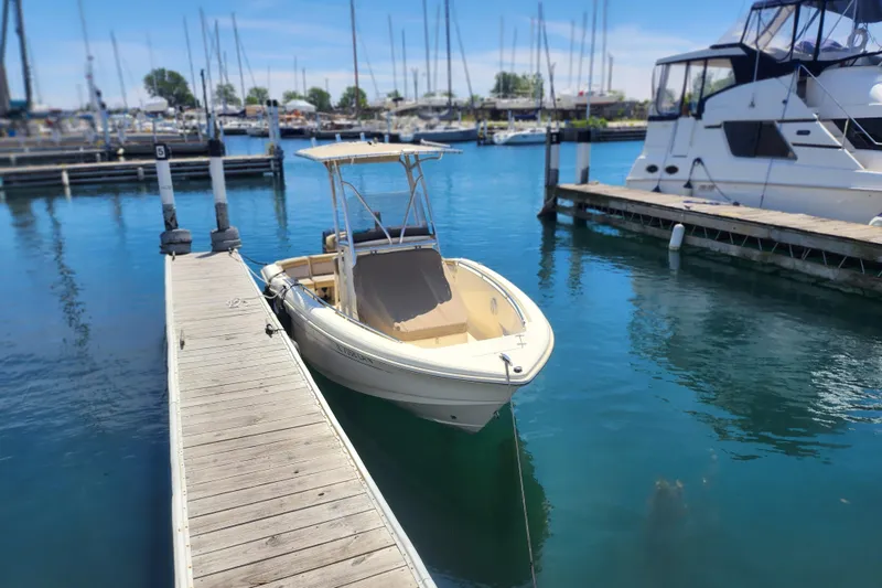 Slide: The Image of 2014 Scout 210 XSF boat docked in a marina with clear blue water. - 3