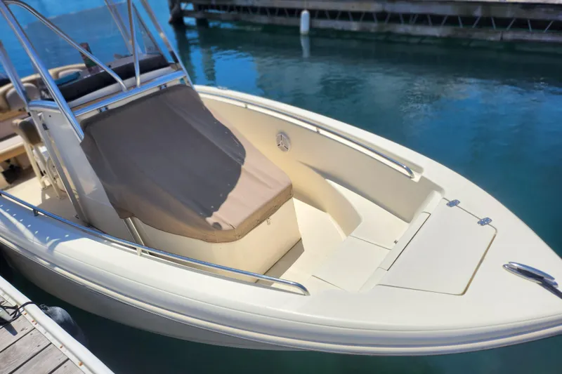Slide: The Image of 2014 Scout 210 XSF boat docked on clear blue water. - 4
