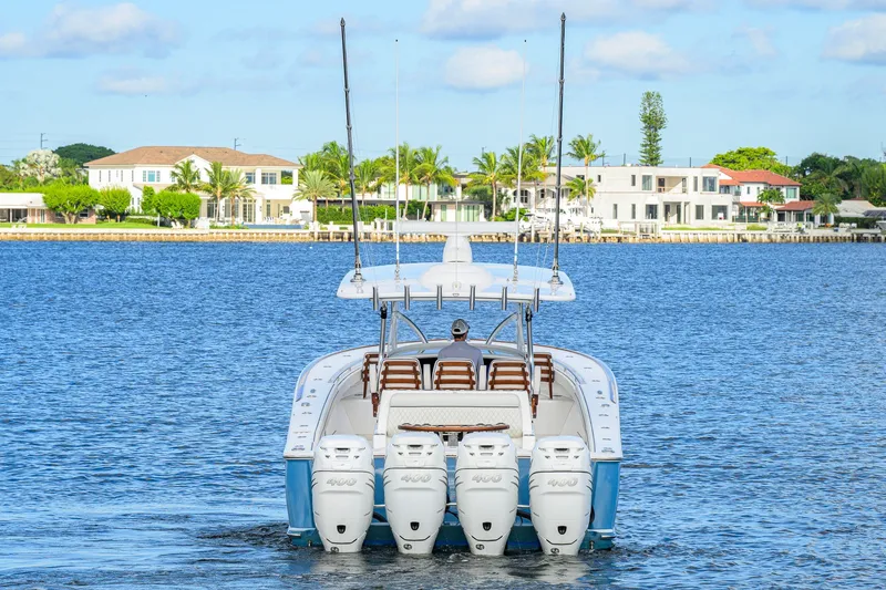 Slide: The Image of Valhalla V-41 2020 boat cruising on a serene waterfront with luxury homes in the background. - 8
