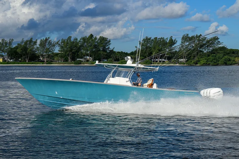 Slide: The Image of 2020 Valhalla V-41 boat cruising on a scenic lake under a partly cloudy sky. - 4