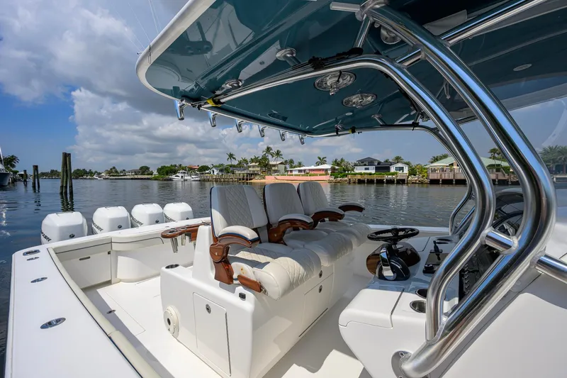 Slide: The Image of 2020 Valhalla Boatworks V-41 luxury boat interior with helm and seating, docked by waterfront homes. - 25