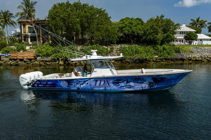 The Image of 2020 Valhalla Boatworks V-41 with custom graphics, cruising near lush waterfront homes. - 0