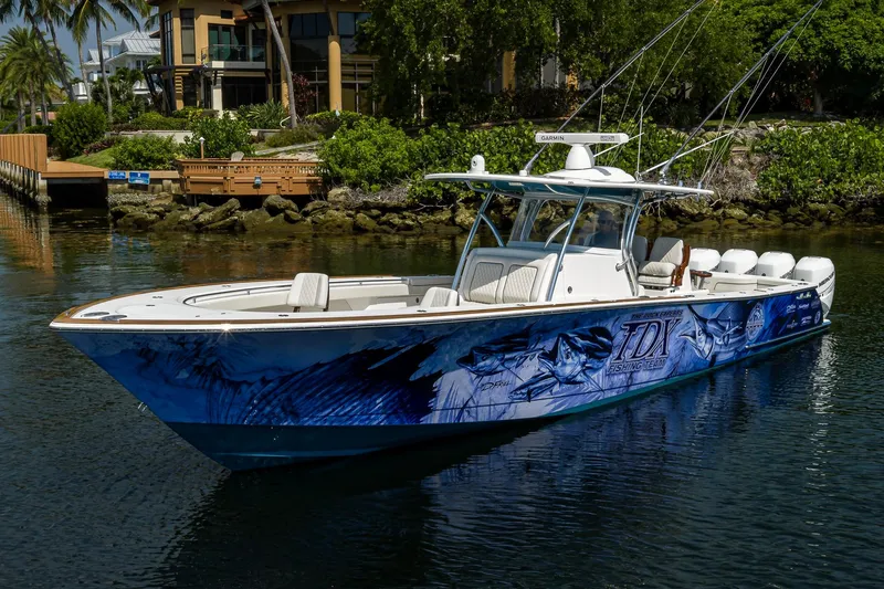 Slide: The Image of 2020 Valhalla Boatworks V-41 with custom graphics, docked near lush greenery. - 7