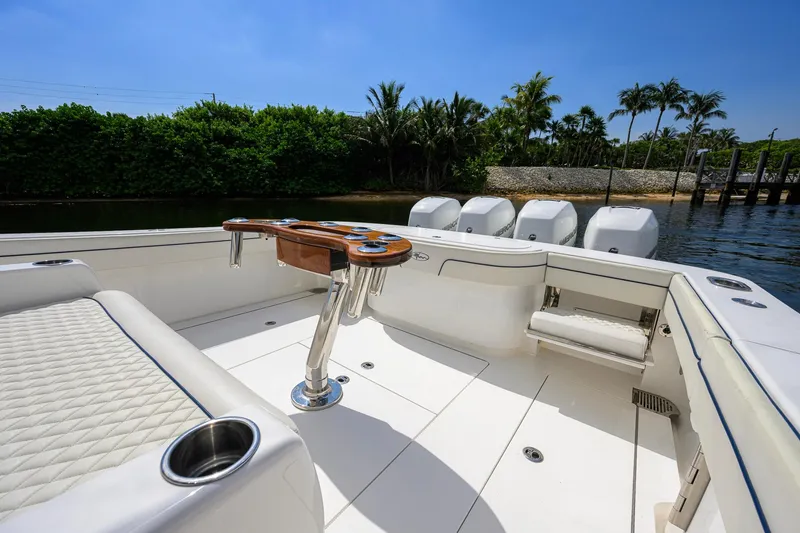 Slide: The Image of 2020 Valhalla Boatworks V-41 interior with seating and rod holders, docked near lush greenery. - 49