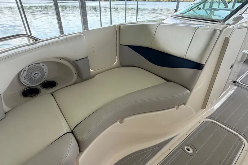 Slide: The Image of Interior seating of a 2010 Bryant 255 boat, featuring cushioned seats and built-in speakers. - 11