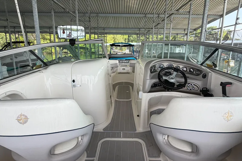 Slide: The Image of Interior view of a 2010 Bryant 255 boat, showcasing steering and seating area. - 13