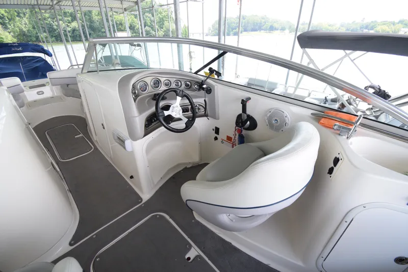 Slide: The Image of The cockpit of a 2010 Bryant 255 boat with a white seat and dashboard. - 14