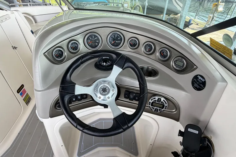 Slide: The Image of Steering wheel and dashboard of a 2010 Bryant 255 boat with gauges and controls. - 17