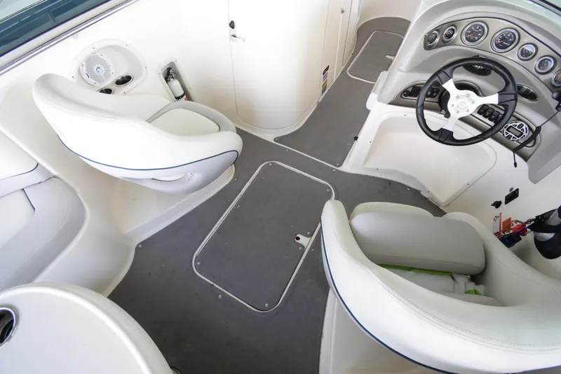 Slide: The Image of Interior of a 2010 Bryant 255 boat with white seating and a helm station. - 19
