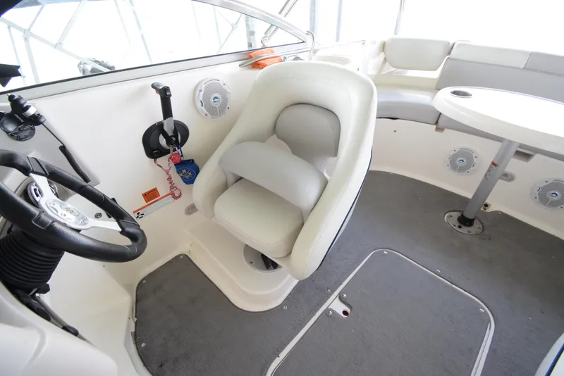 Slide: The Image of The image shows the interior of a 2010 Bryant 255 boat with a white seat and table. - 20