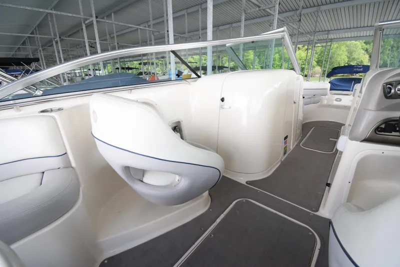 Slide: The Image of The image shows the interior of a 2010 Bryant 255 boat with white seats and gray flooring. - 21