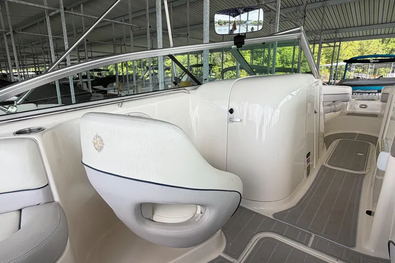 Slide: The Image of 2010 Bryant 255 boat interior with white seating and sleek design in a covered dock. - 24