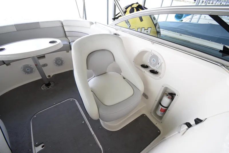 Slide: The Image of Interior of a Bryant 255 boat with a white seat and a table. - 25