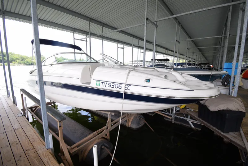 Slide: The Image of A white boat on a lift in a covered dock. - 3